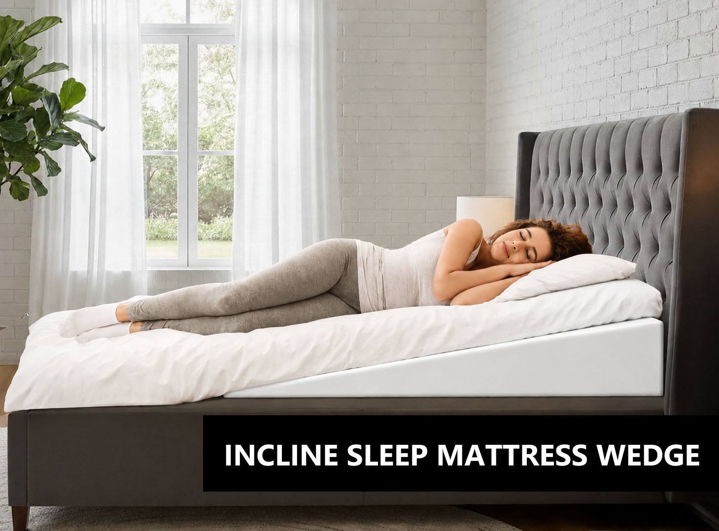 Woman sleeping on a bed with an inclined mattress wedge resting on white bedding with a tufted headboard